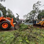 Recolhendo galhos de árvores, fazendo limpeza e religando energia