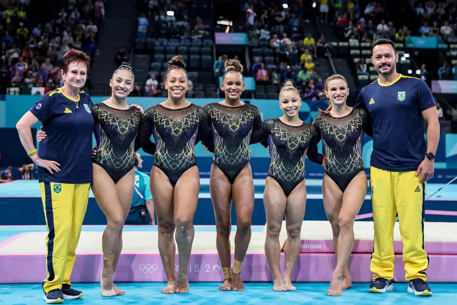 Atleta apoiada pelo Estado, Júlia Soares conquista o bronze na ginástica por equipes em Paris. Na foto, Iryna Ilyashenko, Júlia Soares, Lorrane Oliveira, Rebeca Andrade, Flavia Saraiva e Jade Barbosa e o treinador Francisco Porath Neto. Foto: Miriam Jeske/COB