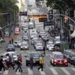 a busy city street with cars and people walking