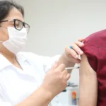 mulher aplicando vacina