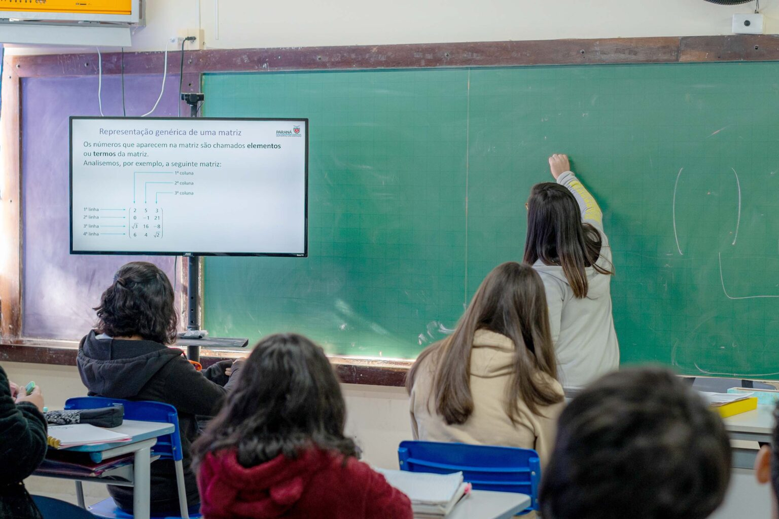 Professor escrevendo no quadro negro
