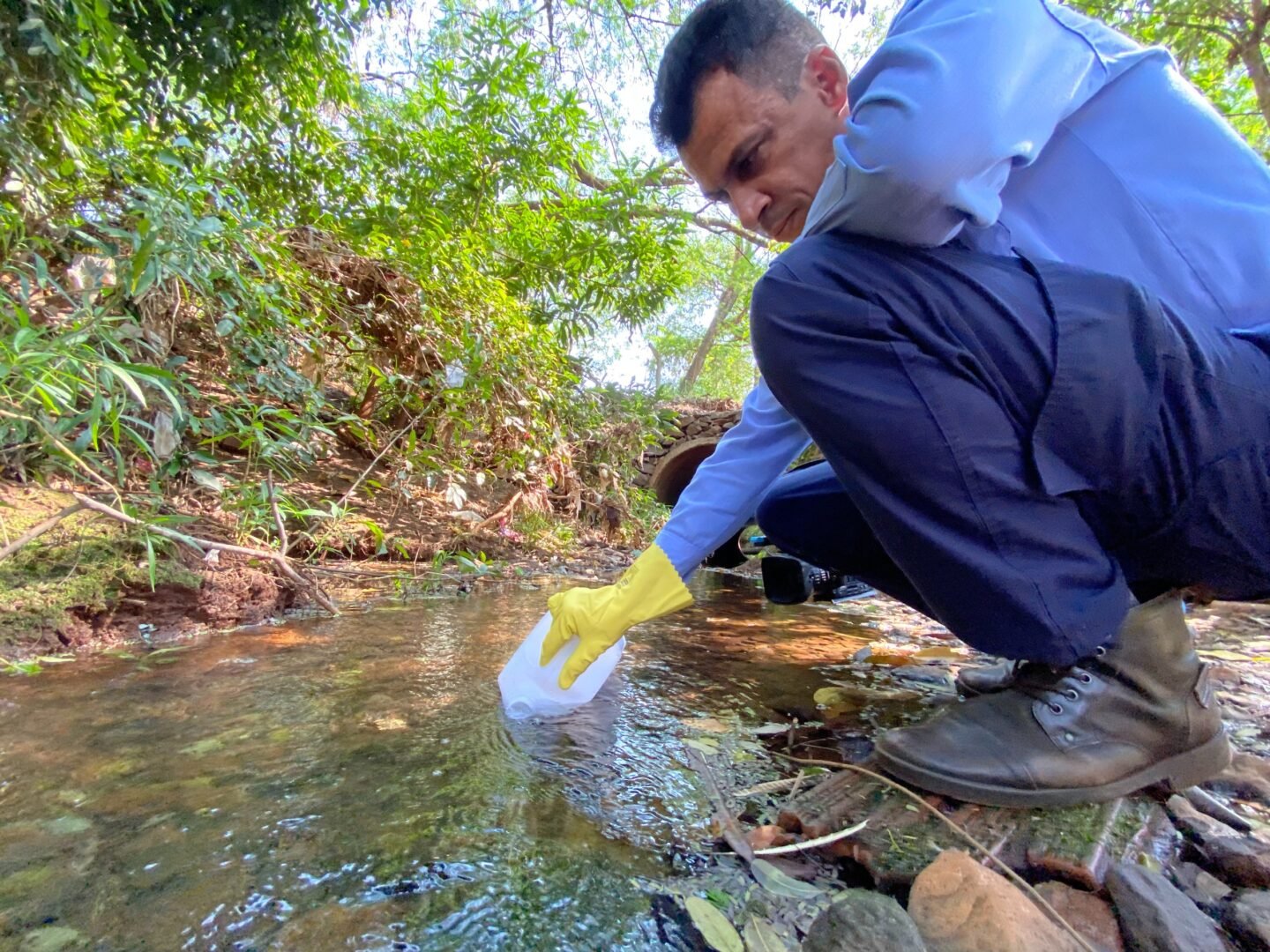 Homem pegando água em um rio
