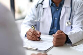 Médico escrevendo no prontuário