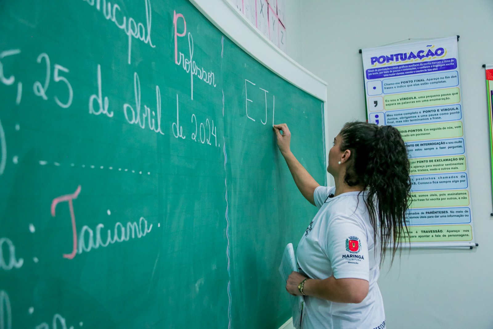 Professora escrevendo no quadro na sala de aula